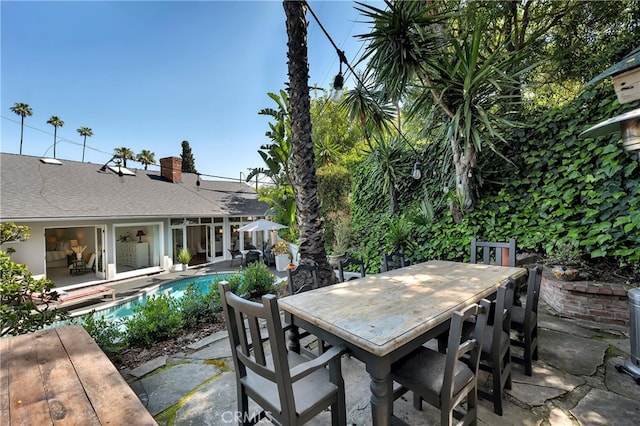 view of patio / terrace featuring outdoor dining area and an outdoor pool