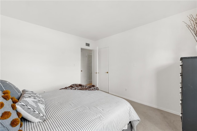 bedroom featuring baseboards, visible vents, and light colored carpet