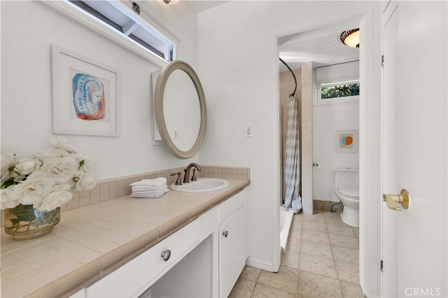 full bath with toilet, baseboards, a shower with shower curtain, and vanity