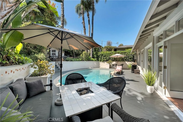 view of patio with a fenced in pool and outdoor dining area