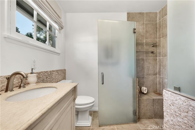 bathroom with vanity, toilet, tile patterned flooring, and a stall shower