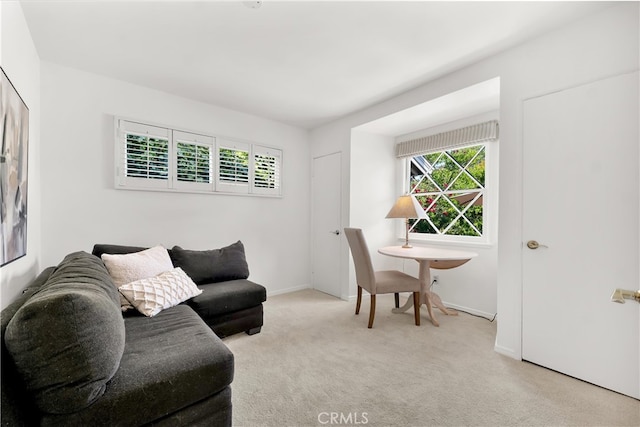 carpeted living room featuring baseboards and a healthy amount of sunlight