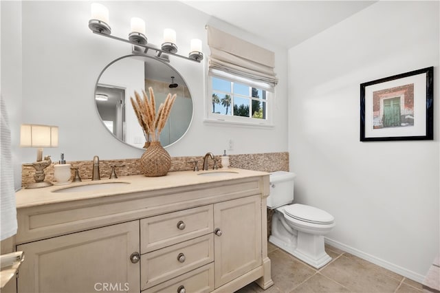full bath with toilet, baseboards, a sink, and tile patterned floors