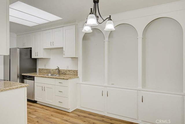 kitchen featuring white cabinetry, a sink, light wood-style flooring, decorative light fixtures, and stainless steel appliances