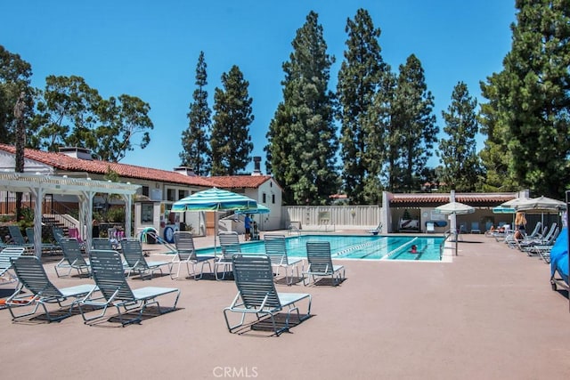 pool with a patio area, fence, and a pergola