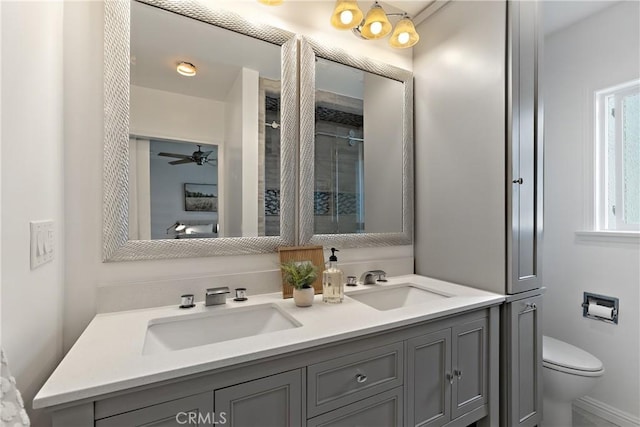 full bath featuring double vanity, a sink, and toilet