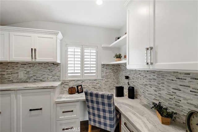 kitchen with decorative backsplash, white cabinets, open shelves, and light stone counters