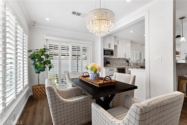 dining room featuring a chandelier, dark wood-style floors, ornamental molding, and visible vents