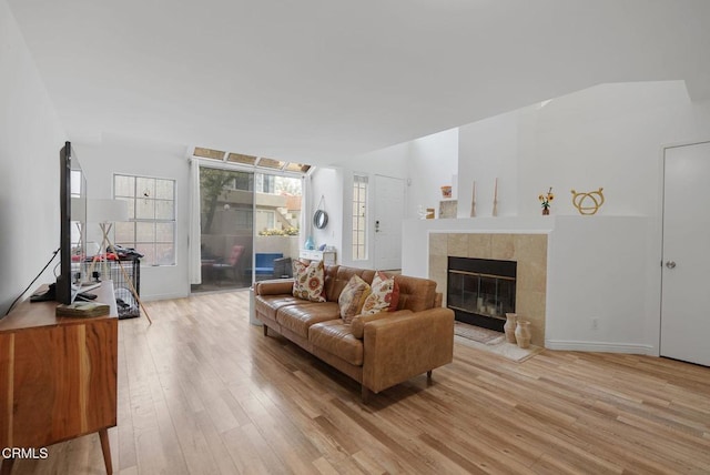 living room with light wood-style flooring and a tile fireplace