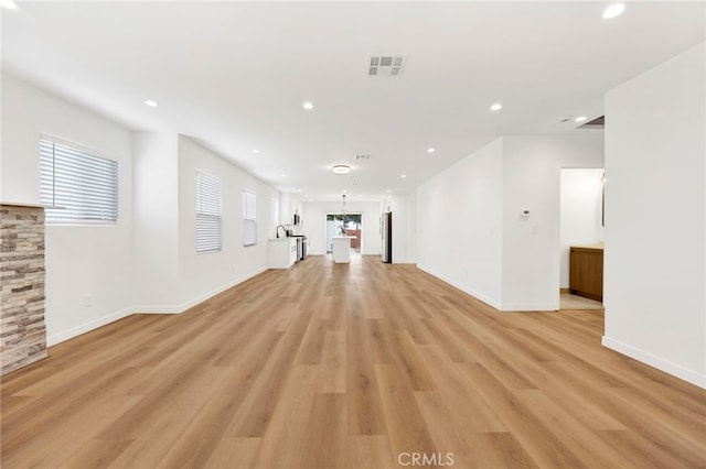 unfurnished living room with light wood-type flooring, recessed lighting, and visible vents
