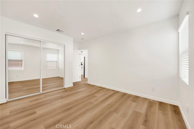 unfurnished bedroom with visible vents, recessed lighting, a closet, and light wood-type flooring