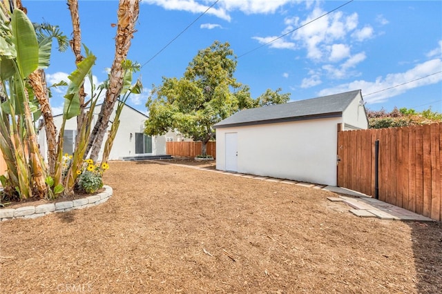 view of yard featuring fence, an outbuilding, and a shed