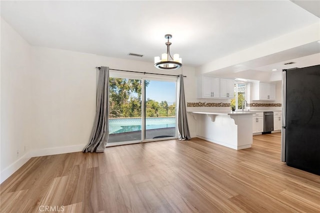23341 Bessemer St, Woodland Hills, CA 91367 - kitchen featuring stainless steel appliances, white cabinetry, a peninsula, light wood-type flooring, and visible vents