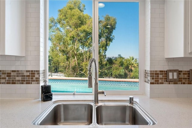 23341 Bessemer St, Woodland Hills, CA 91367 - room details with light stone counters, a sink, backsplash, and white cabinets