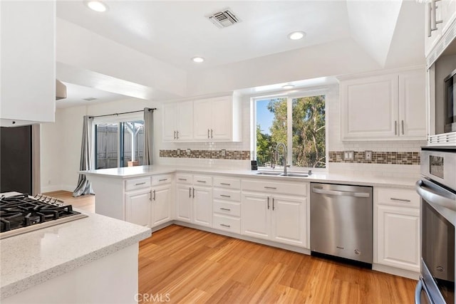 23341 Bessemer St, Woodland Hills, CA 91367 - kitchen with visible vents, light wood-type flooring, a sink, a peninsula, and stainless steel appliances