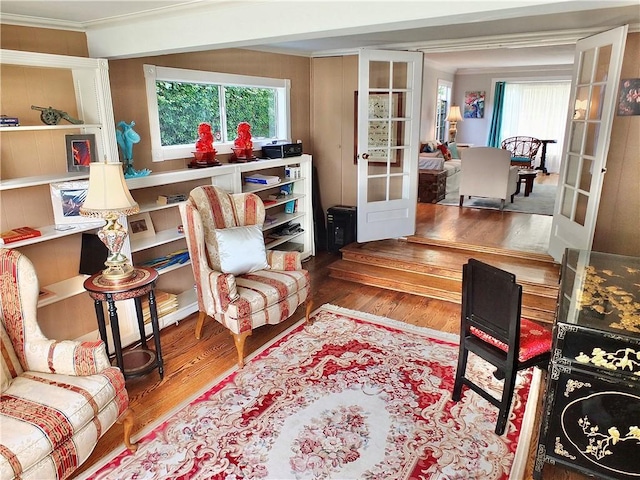 interior space with french doors, crown molding, and wood finished floors
