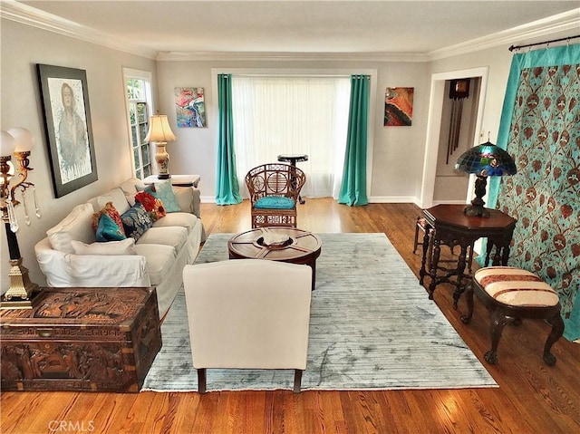 living room featuring baseboards, ornamental molding, and wood finished floors