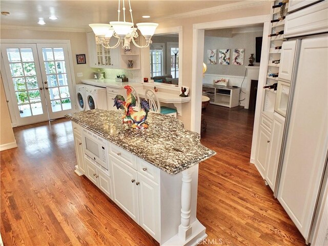 3835 California Ave, Long Beach, CA 90807 - kitchen with white microwave, crown molding, a center island, a chandelier, and white cabinetry