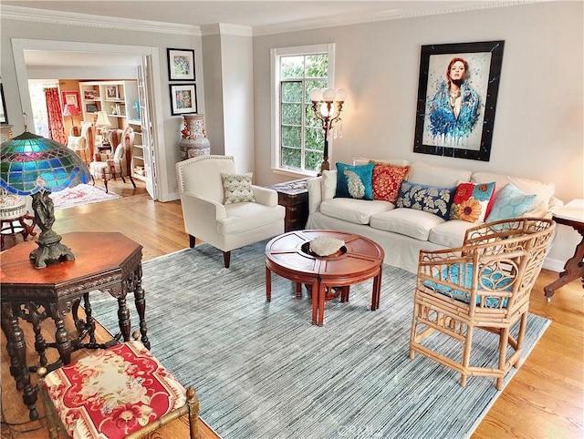 living area with baseboards, ornamental molding, and light wood-style flooring