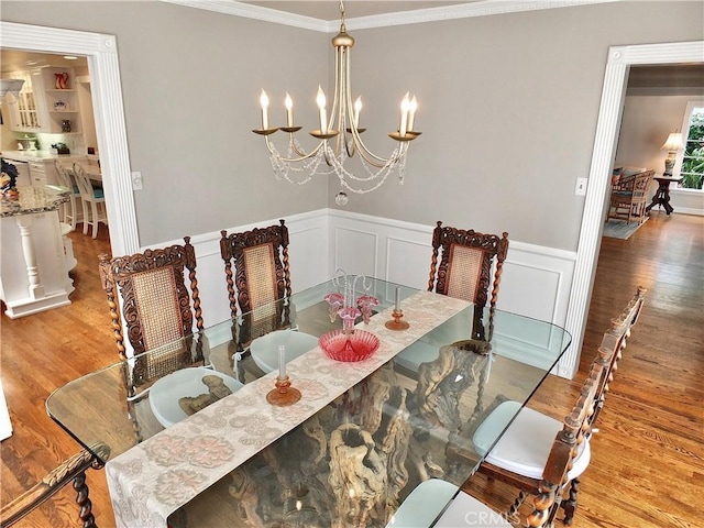 3835 California Ave, Long Beach, CA 90807 - dining area featuring ornamental molding, light wood-type flooring, wainscoting, a chandelier, and a decorative wall
