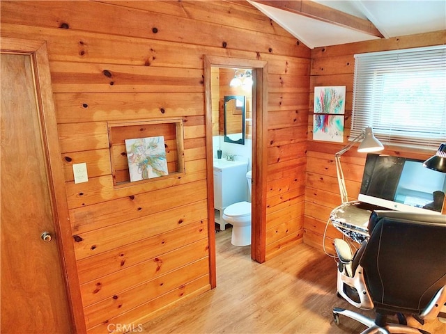 office space featuring wood walls, light wood-style flooring, washer / clothes dryer, and lofted ceiling