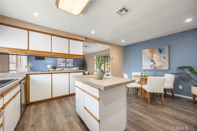 3881 Valle Vista Dr, Chino Hills, CA 91709 - kitchen featuring wood finished floors, light countertops, white cabinetry, stainless steel dishwasher, and recessed lighting