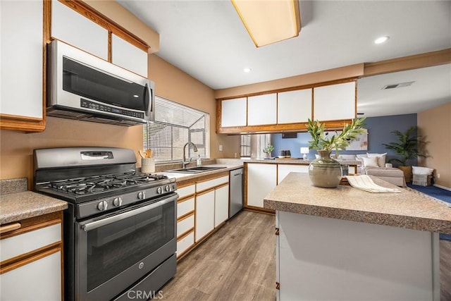 3881 Valle Vista Dr, Chino Hills, CA 91709 - kitchen featuring stainless steel appliances, a sink, light wood-type flooring, white cabinetry, and recessed lighting