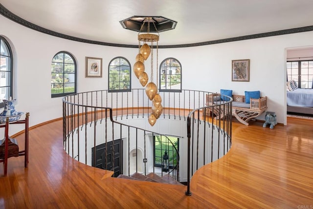staircase with crown molding, baseboards, and wood finished floors