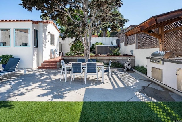 view of patio / terrace with fence, outdoor dining space, grilling area, and an outdoor kitchen