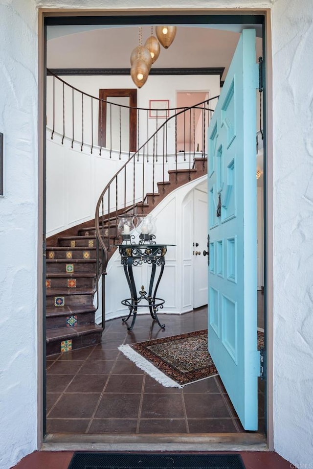 entrance foyer featuring dark tile patterned flooring and stairs