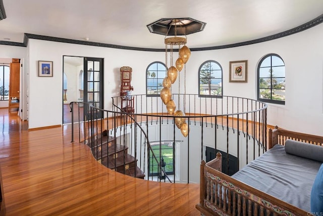 stairs with baseboards, ornamental molding, and wood finished floors