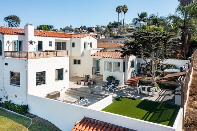 back of house with fence, a patio, stucco siding, a chimney, and a tiled roof