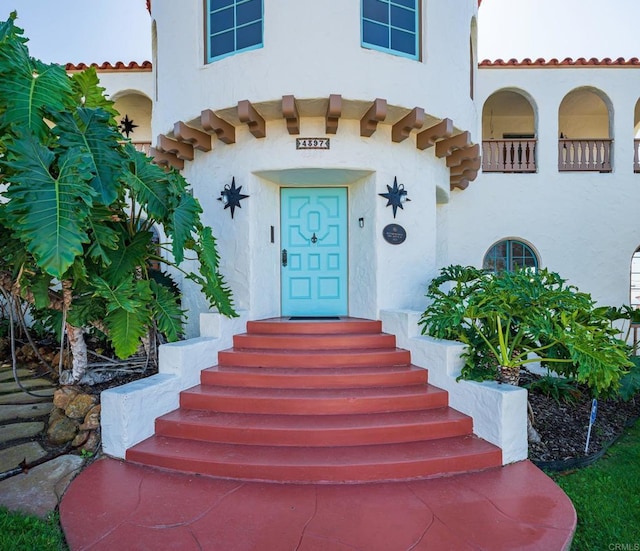 entrance to property with stucco siding and a tiled roof
