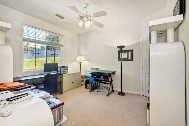 home office featuring light carpet, a ceiling fan, and visible vents