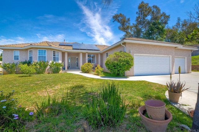 single story home featuring a front yard, stucco siding, concrete driveway, an attached garage, and solar panels
