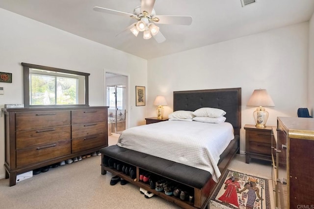 bedroom with ensuite bathroom, ceiling fan, and light colored carpet