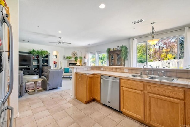 kitchen featuring tile countertops, visible vents, dishwasher, a sink, and open floor plan
