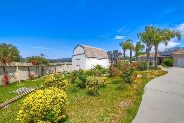 view of yard with fence, an outbuilding, and a storage unit