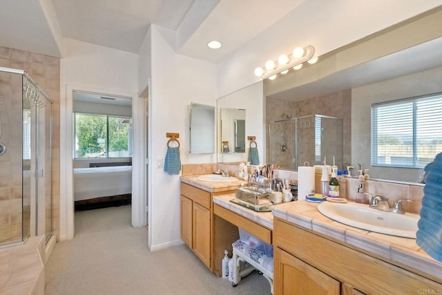 ensuite bathroom with plenty of natural light, a sink, and a stall shower