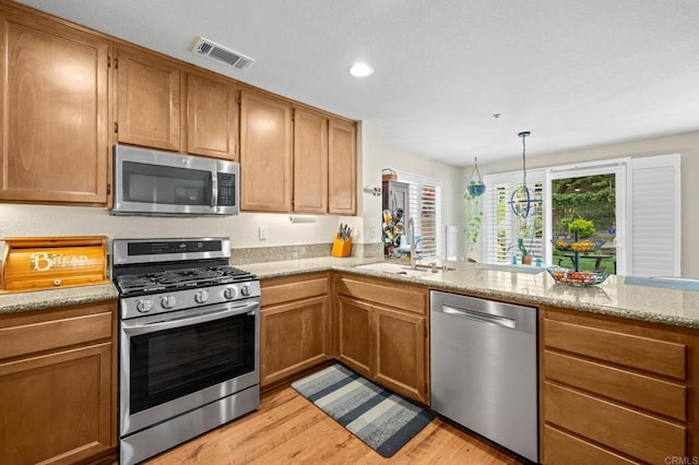 1752 Cottonwood Dr, Vista, CA 92081 - kitchen with appliances with stainless steel finishes, a sink, light wood-style flooring, recessed lighting, and light stone countertops