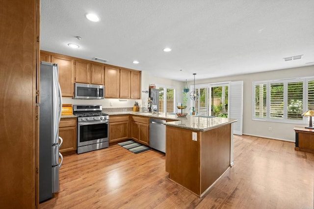 1752 Cottonwood Dr, Vista, CA 92081 - kitchen featuring appliances with stainless steel finishes, a peninsula, healthy amount of natural light, light wood-style floors, and recessed lighting
