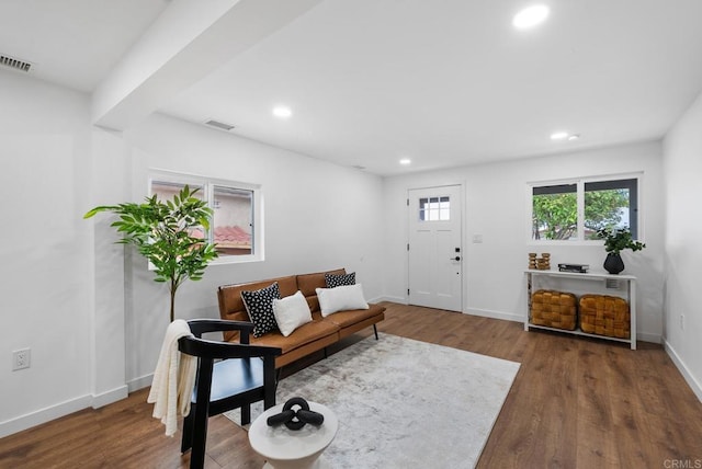 living area with baseboards, recessed lighting, wood finished floors, and visible vents