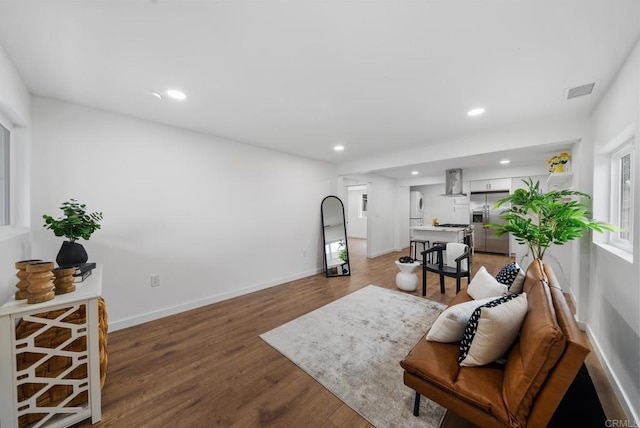 living room with plenty of natural light, light wood finished floors, and recessed lighting
