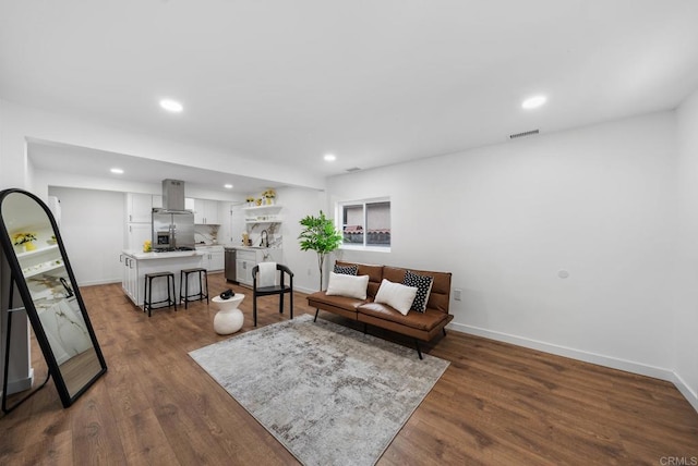 living area with dark wood-style flooring, baseboards, visible vents, and recessed lighting