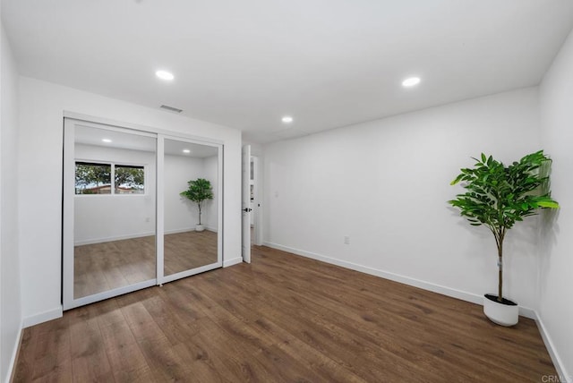unfurnished bedroom featuring recessed lighting, baseboards, visible vents, and wood finished floors