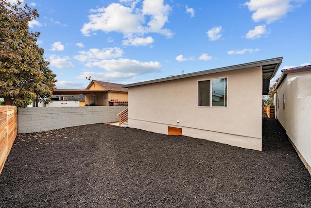 back of property featuring a fenced backyard and stucco siding