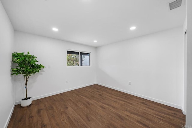 empty room with recessed lighting, baseboards, visible vents, and dark wood-style floors