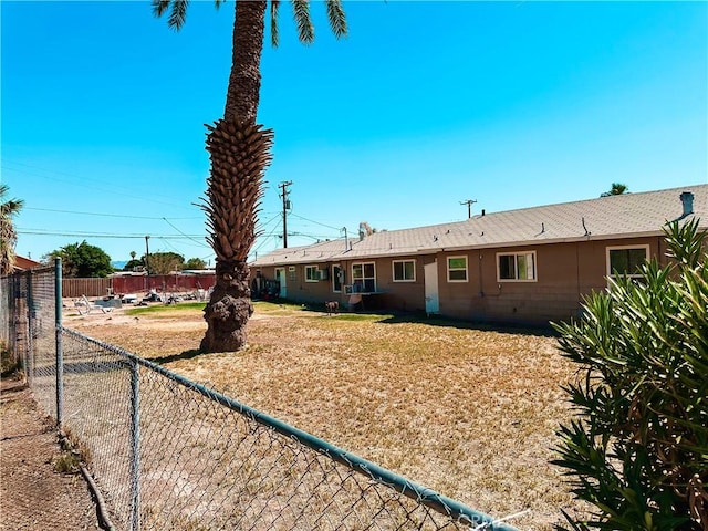back of house with a fenced backyard