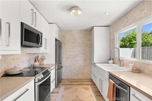 22352 Torino, Laguna Hills, CA 92653 - kitchen with appliances with stainless steel finishes, light wood-style flooring, and white cabinetry