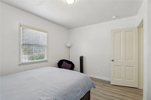 bedroom with baseboards and light wood finished floors